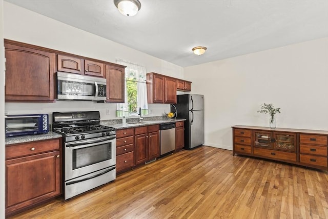 4-6 Marcella St Unit 2, Boston, MA 02119 - kitchen with appliances with stainless steel finishes, light wood finished floors, dark stone countertops, and a sink