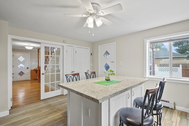 0 Steeple View Way, Leominster, MA 01453 - kitchen featuring a baseboard radiator, light wood finished floors, light countertops, and a center island