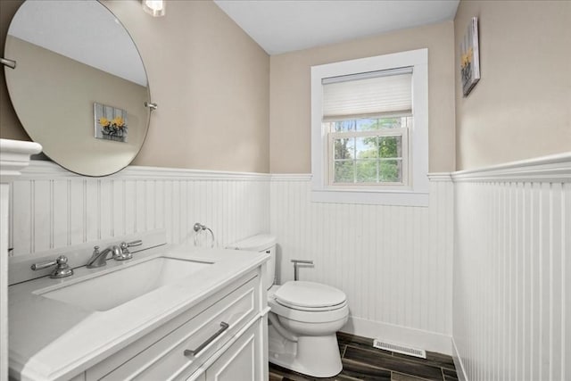 40 Richard Ave, Shrewsbury, MA 01545 - bathroom with wainscoting, toilet, vanity, wood finished floors, and baseboards