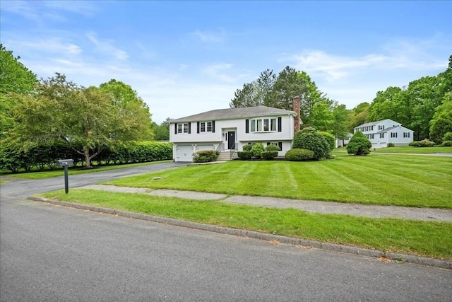 40 Richard Ave, Shrewsbury, MA 01545 - bi-level home with driveway, a chimney, a garage, and a front yard