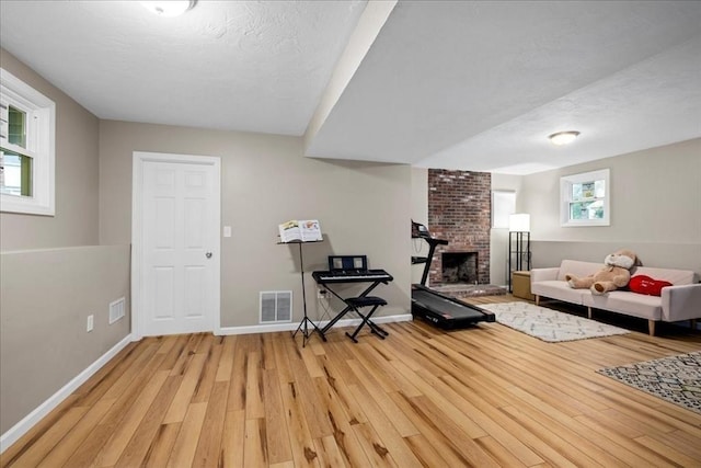 40 Richard Ave, Shrewsbury, MA 01545 - living area featuring light wood-style floors, a fireplace, baseboards, and a textured ceiling