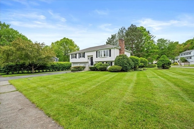 40 Richard Ave, Shrewsbury, MA 01545 - bi-level home featuring a chimney, a front lawn, an attached garage, and asphalt driveway