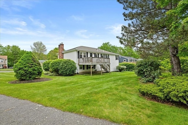 40 Richard Ave, Shrewsbury, MA 01545 - view of front of home with a chimney, a deck, a front lawn, and stairs