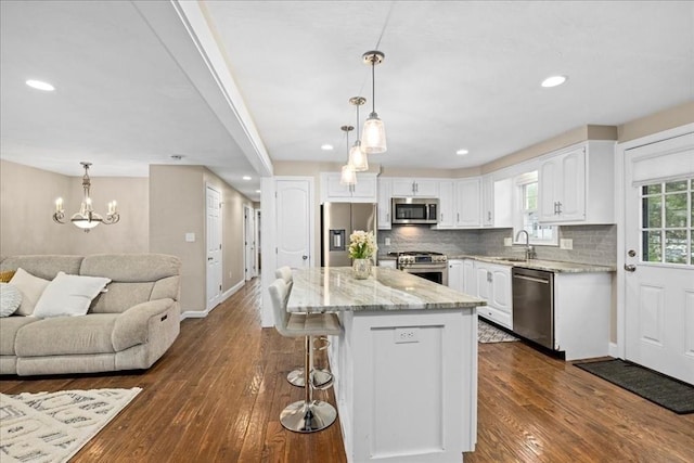 40 Richard Ave, Shrewsbury, MA 01545 - kitchen featuring appliances with stainless steel finishes, open floor plan, white cabinets, a sink, and tasteful backsplash
