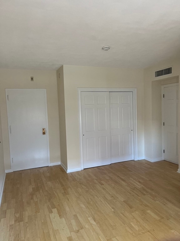 unfurnished bedroom featuring a closet and light hardwood / wood-style flooring