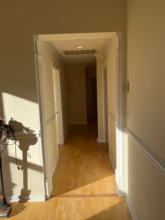 hall featuring light hardwood / wood-style floors and ornamental molding