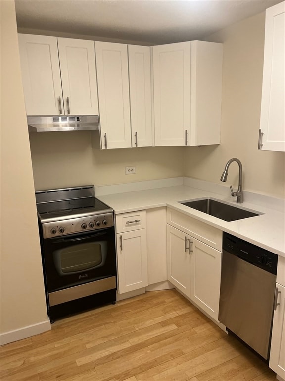 kitchen featuring white cabinetry, sink, stainless steel appliances, and light hardwood / wood-style flooring