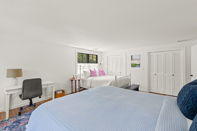 bedroom with hardwood / wood-style flooring and multiple closets