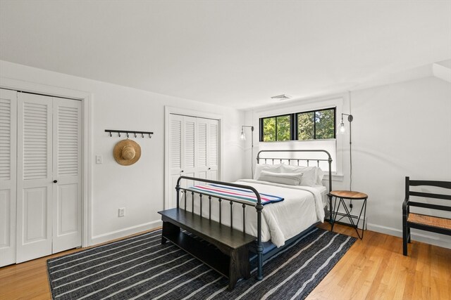 bedroom featuring hardwood / wood-style floors and two closets