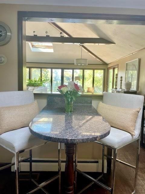 sunroom / solarium featuring lofted ceiling with beams and plenty of natural light