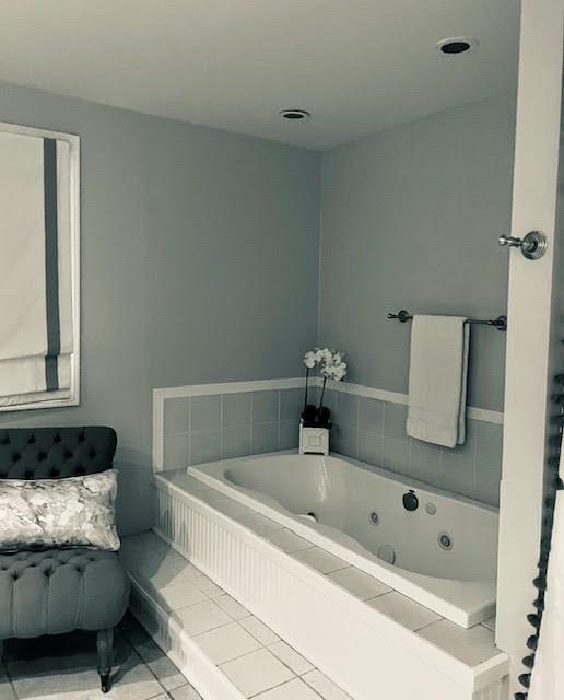 full bath featuring tile patterned flooring and a tub with jets