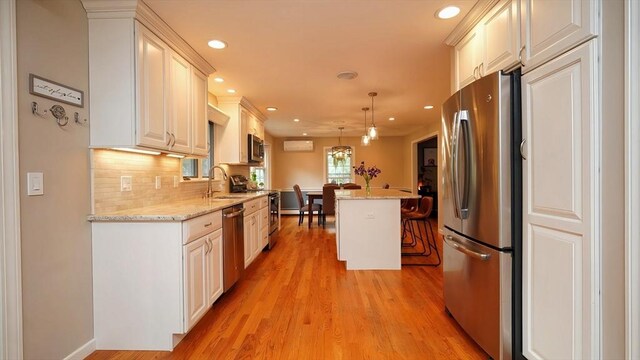 36 Jean Dr, North Attleboro, MA 02760 - kitchen featuring stainless steel appliances, a kitchen bar, a wall mounted AC, light wood finished floors, and recessed lighting