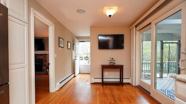 36 Jean Dr, North Attleboro, MA 02760 - entryway with a baseboard heating unit, light wood-style floors, and a brick fireplace