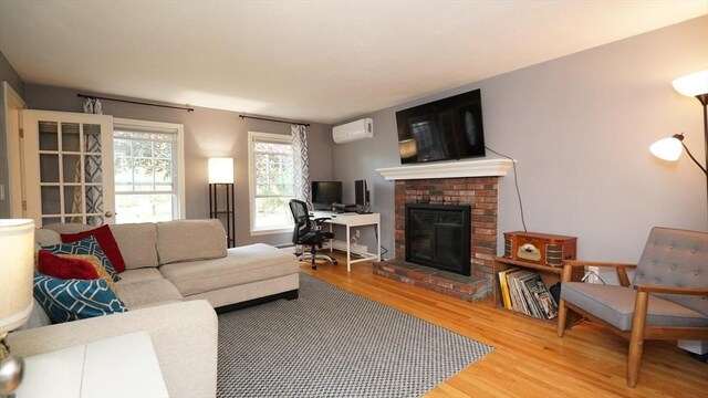 36 Jean Dr, North Attleboro, MA 02760 - living room with a wall unit AC, wood finished floors, and a brick fireplace