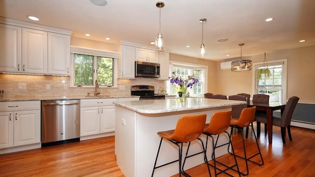 36 Jean Dr, North Attleboro, MA 02760 - kitchen with stainless steel appliances, a sink, a center island, decorative backsplash, and white cabinets