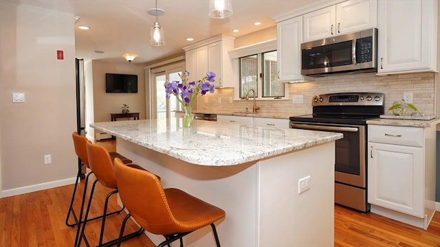 36 Jean Dr, North Attleboro, MA 02760 - kitchen with stainless steel appliances, a sink, decorative backsplash, a kitchen island, and recessed lighting