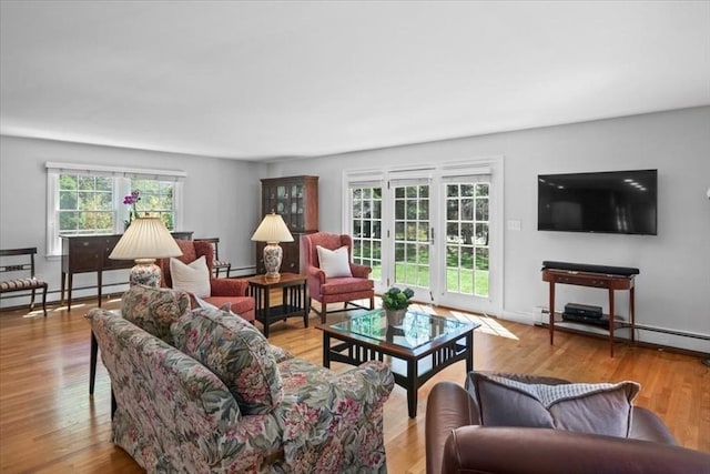 living area featuring wood finished floors, a baseboard heating unit, and baseboard heating