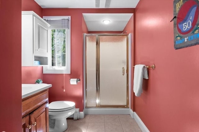 bathroom featuring baseboards, tile patterned floors, a stall shower, and toilet