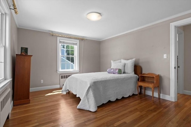 bedroom with crown molding, radiator, and baseboards