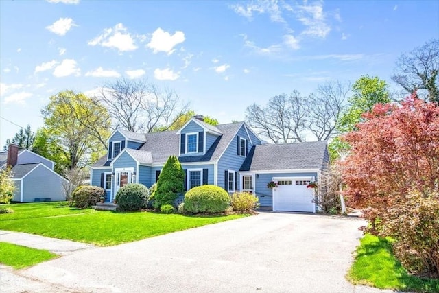 cape cod-style house featuring an attached garage, a front yard, and aphalt driveway