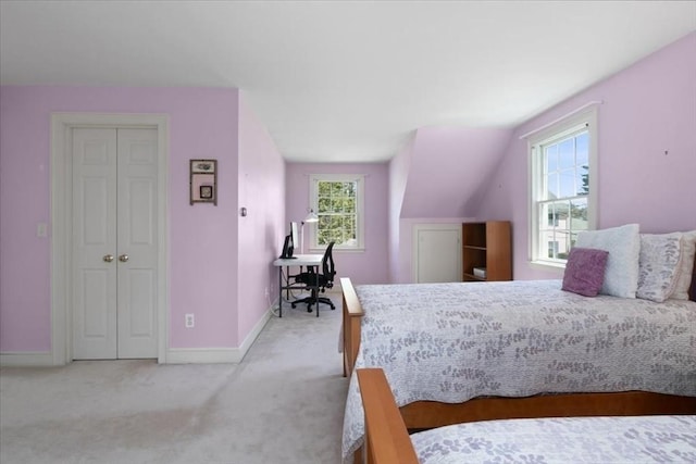 carpeted bedroom with baseboards, multiple windows, and a closet