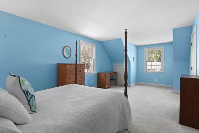 bedroom with baseboards, multiple windows, vaulted ceiling, and light carpet