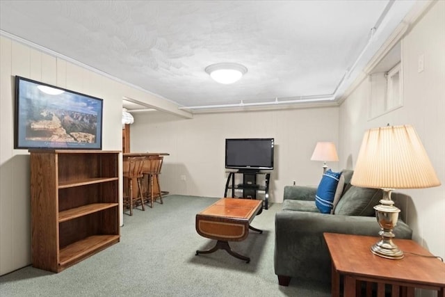 carpeted living area with a bar and crown molding