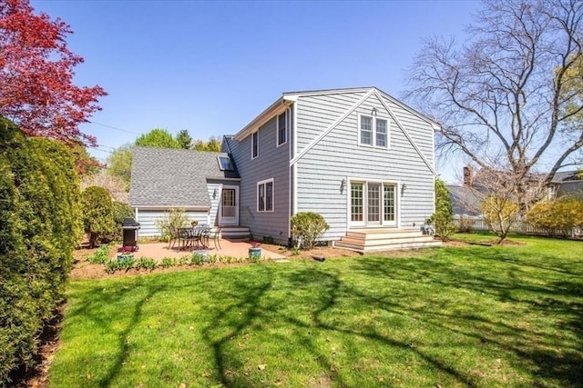 rear view of property featuring a patio, a lawn, and entry steps
