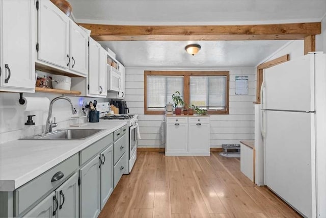 kitchen featuring white appliances, a sink, open shelves, light wood-style flooring, and light countertops
