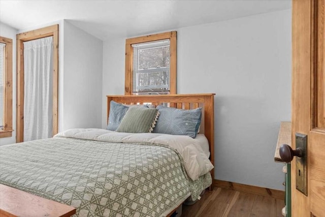 bedroom with wood finished floors and baseboards