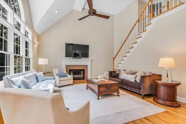 10 Whitney Rd, Stow, MA 01775 - living area featuring high vaulted ceiling, ceiling fan, wood finished floors, stairway, and a brick fireplace