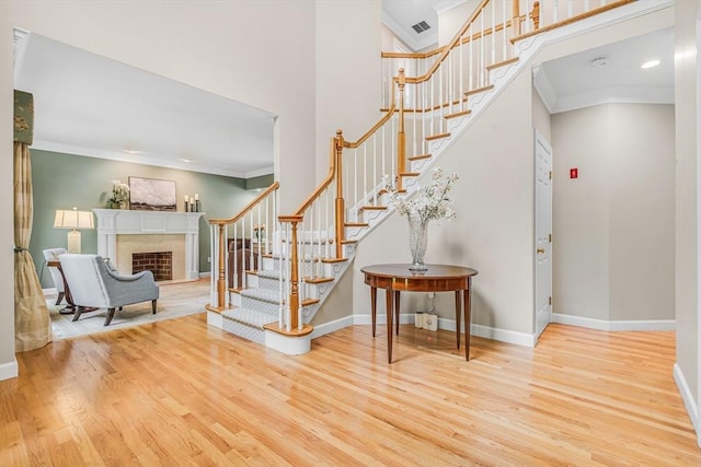 10 Whitney Rd, Stow, MA 01775 - foyer entrance featuring wood finished floors, stairs, a fireplace, ornamental molding, and baseboards