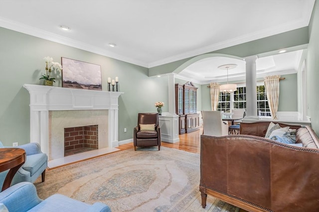 10 Whitney Rd, Stow, MA 01775 - living area with wood finished floors, decorative columns, crown molding, a fireplace, and arched walkways