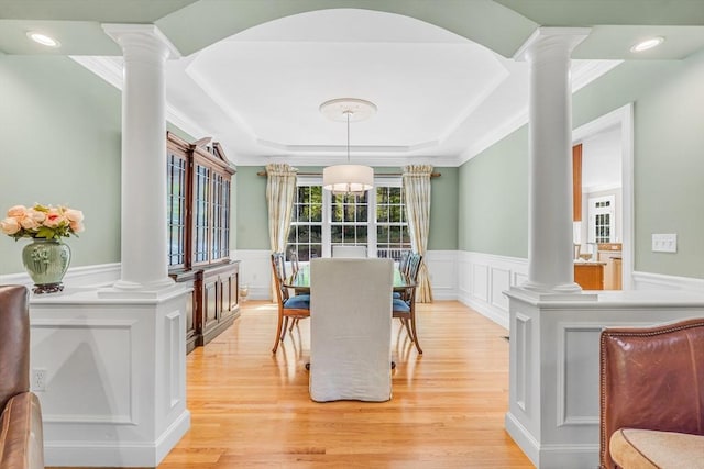 10 Whitney Rd, Stow, MA 01775 - dining area featuring decorative columns, a decorative wall, light wood-style floors, a wainscoted wall, and a tray ceiling
