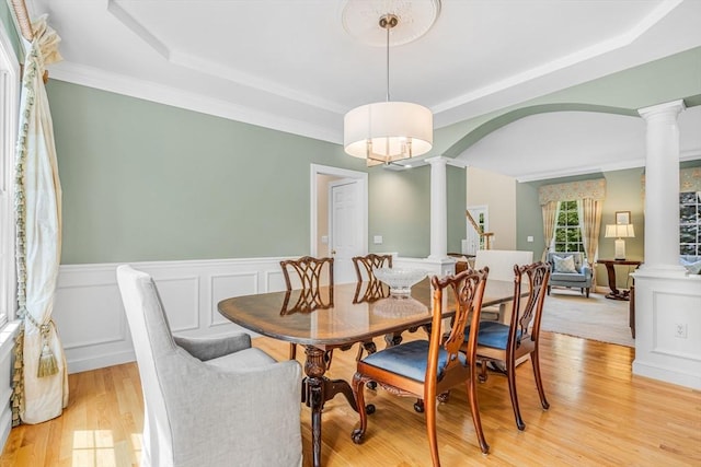 10 Whitney Rd, Stow, MA 01775 - dining space with decorative columns, a tray ceiling, light wood-style flooring, wainscoting, and crown molding
