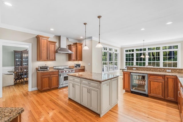 10 Whitney Rd, Stow, MA 01775 - kitchen with beverage cooler, high end stove, wall chimney range hood, brown cabinetry, and ornamental molding