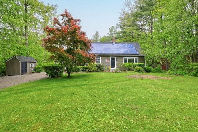 83 Everett Rd, Barre, MA 01005 - single story home with roof mounted solar panels, a front lawn, a chimney, and gravel driveway