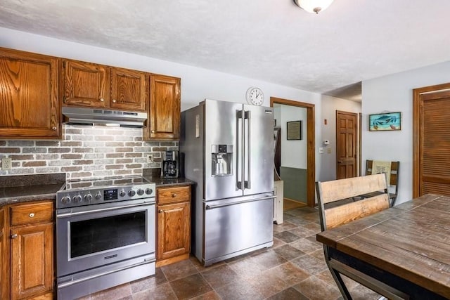 83 Everett Rd, Barre, MA 01005 - kitchen featuring appliances with stainless steel finishes, under cabinet range hood, dark countertops, and brown cabinetry
