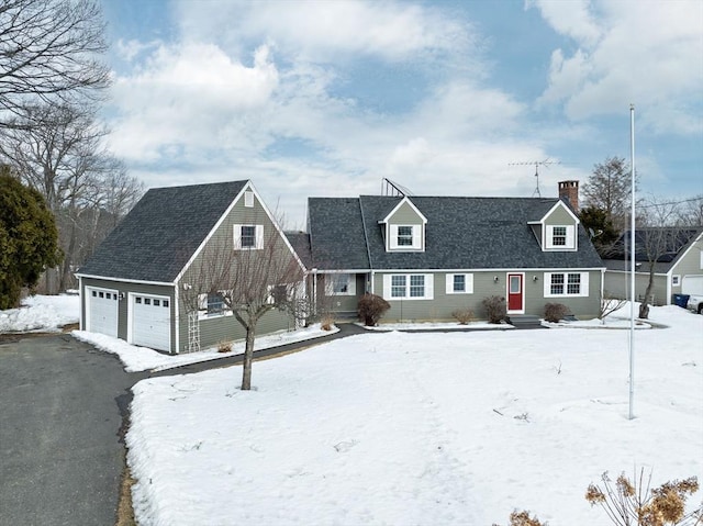 new england style home with a garage, roof with shingles, a chimney, and aphalt driveway