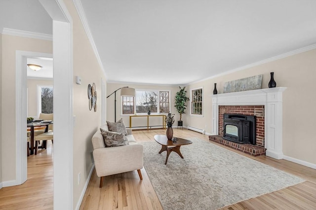 living room featuring ornamental molding, baseboard heating, light wood-type flooring, and a wealth of natural light