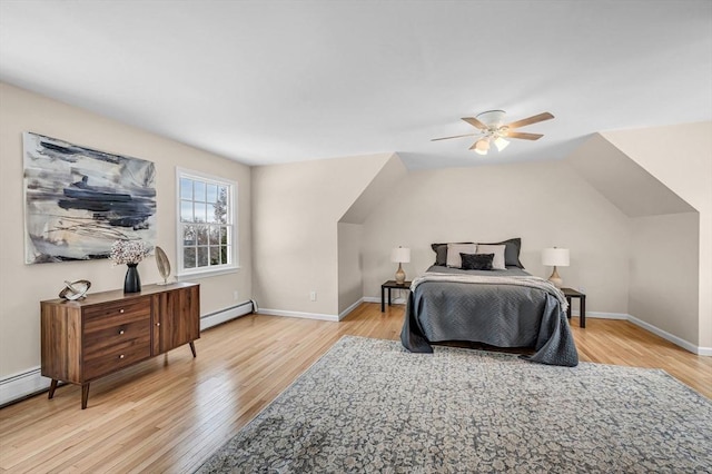 bedroom featuring lofted ceiling, light wood finished floors, a baseboard radiator, and baseboards