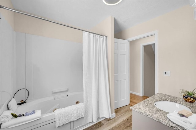 bathroom featuring vanity, shower / tub combo with curtain, and wood finished floors