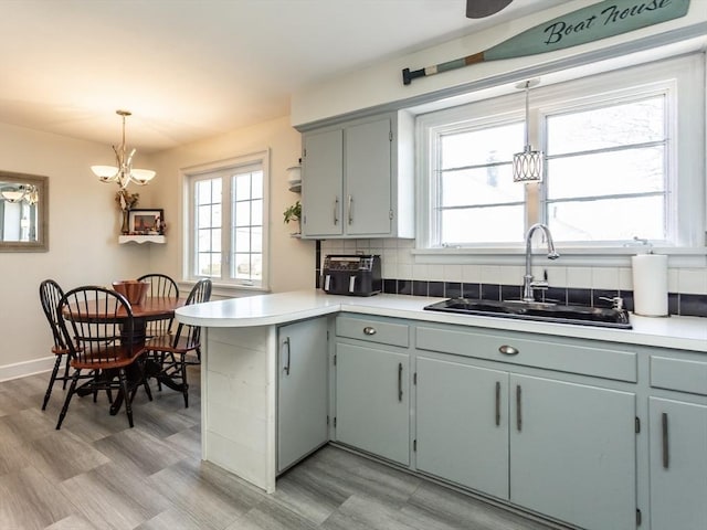 kitchen with pendant lighting, sink, tasteful backsplash, and a healthy amount of sunlight