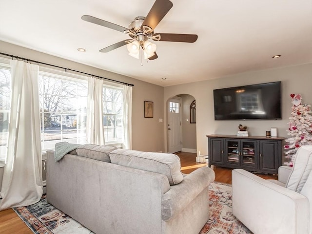 living room featuring a baseboard heating unit, ceiling fan, and light hardwood / wood-style flooring