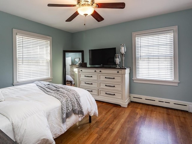 bedroom featuring baseboard heating, ceiling fan, and dark hardwood / wood-style flooring