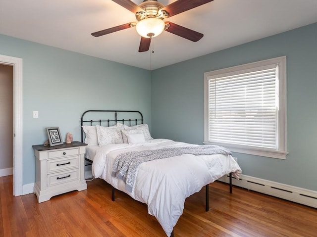 bedroom with hardwood / wood-style floors, a baseboard radiator, and ceiling fan