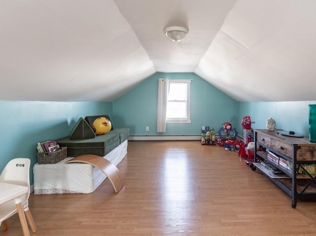 interior space with hardwood / wood-style flooring, a baseboard radiator, and lofted ceiling