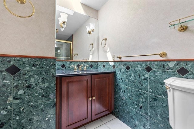bathroom with vanity, tile patterned floors, tile walls, and a stall shower