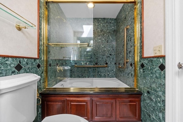 bathroom with toilet, tile walls, and combined bath / shower with glass door
