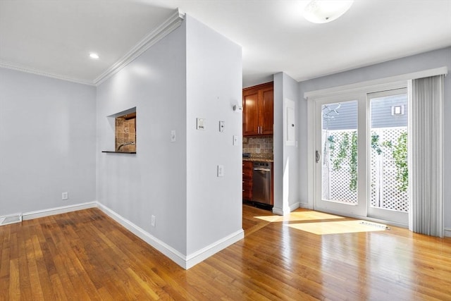 unfurnished room with baseboards, ornamental molding, and wood finished floors